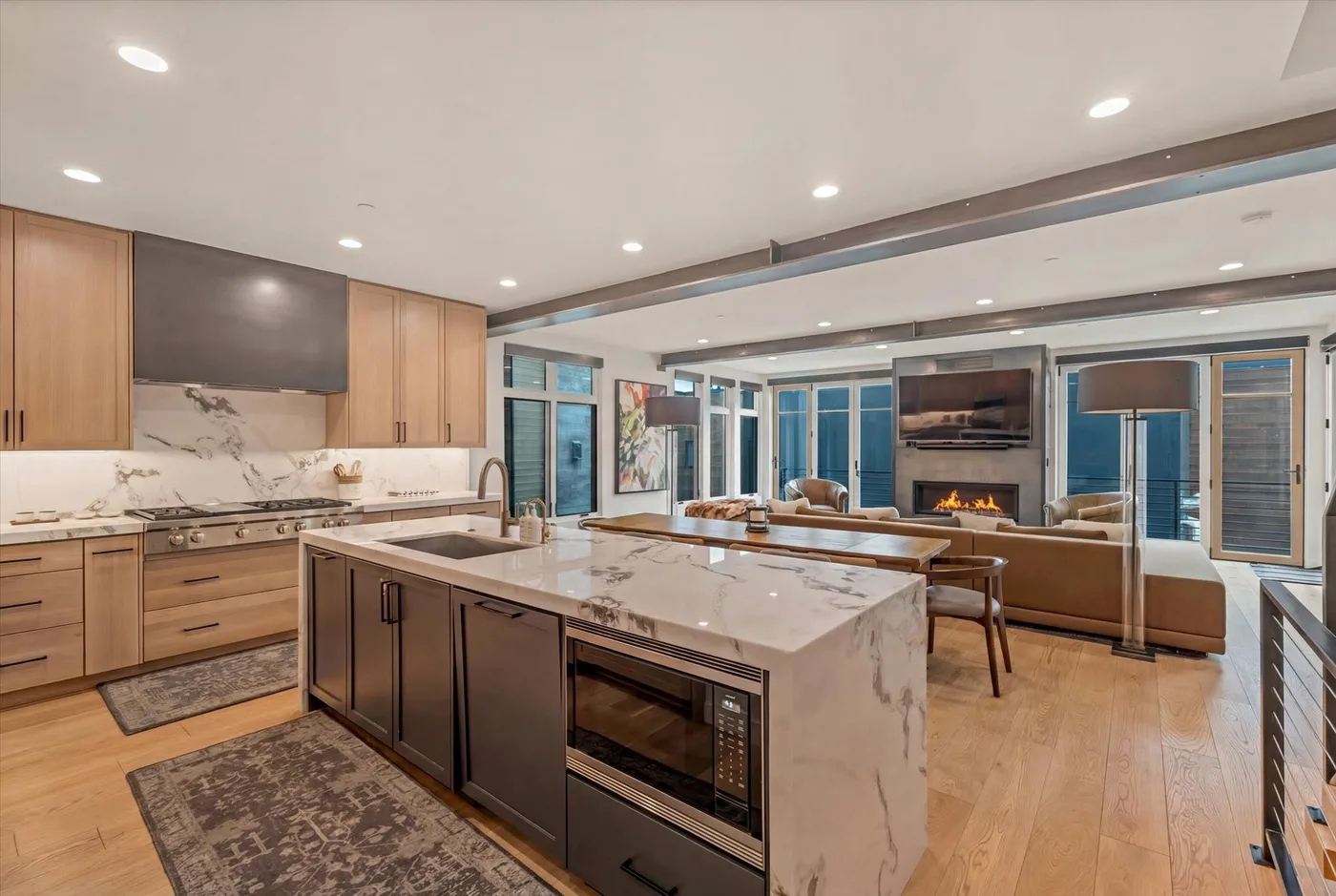 An open-plan kitchen and living area with a central island and fireplace.