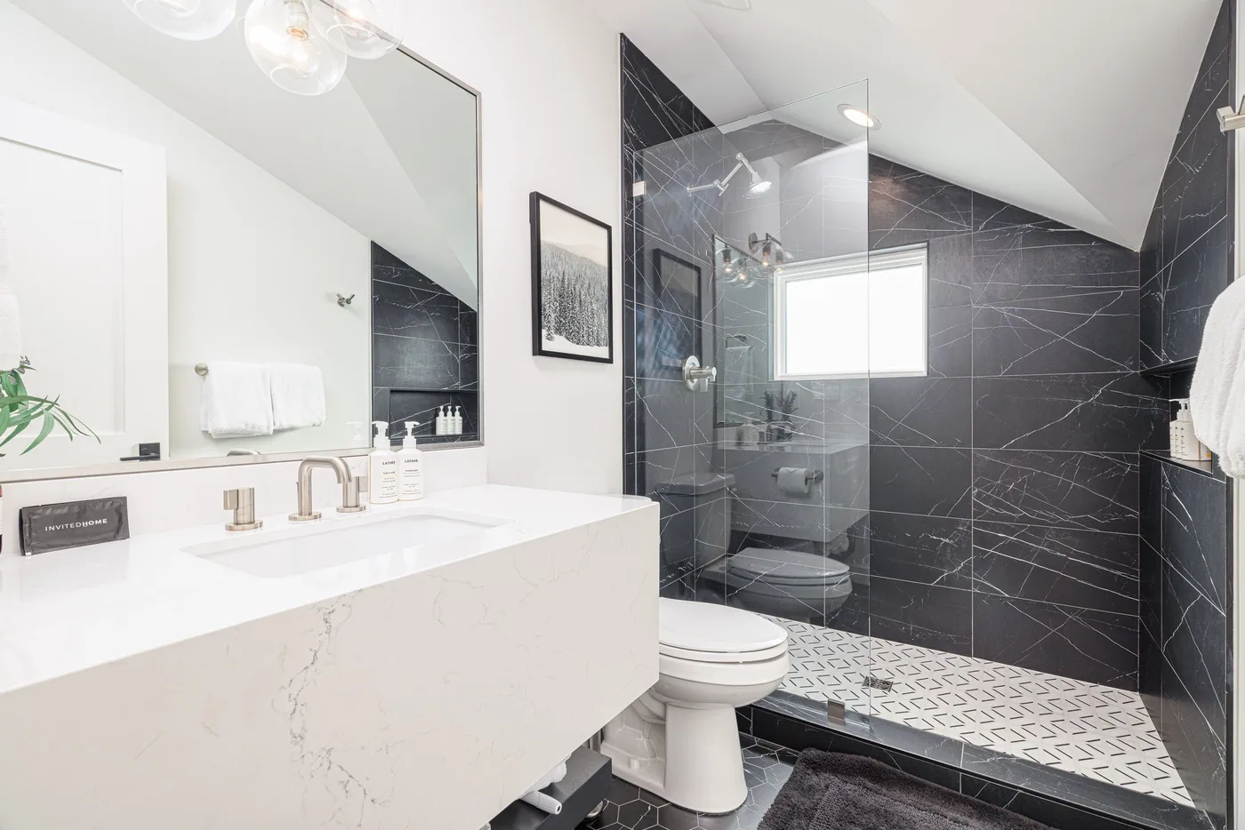 A modern bathroom with a double sink vanity and glass shower.