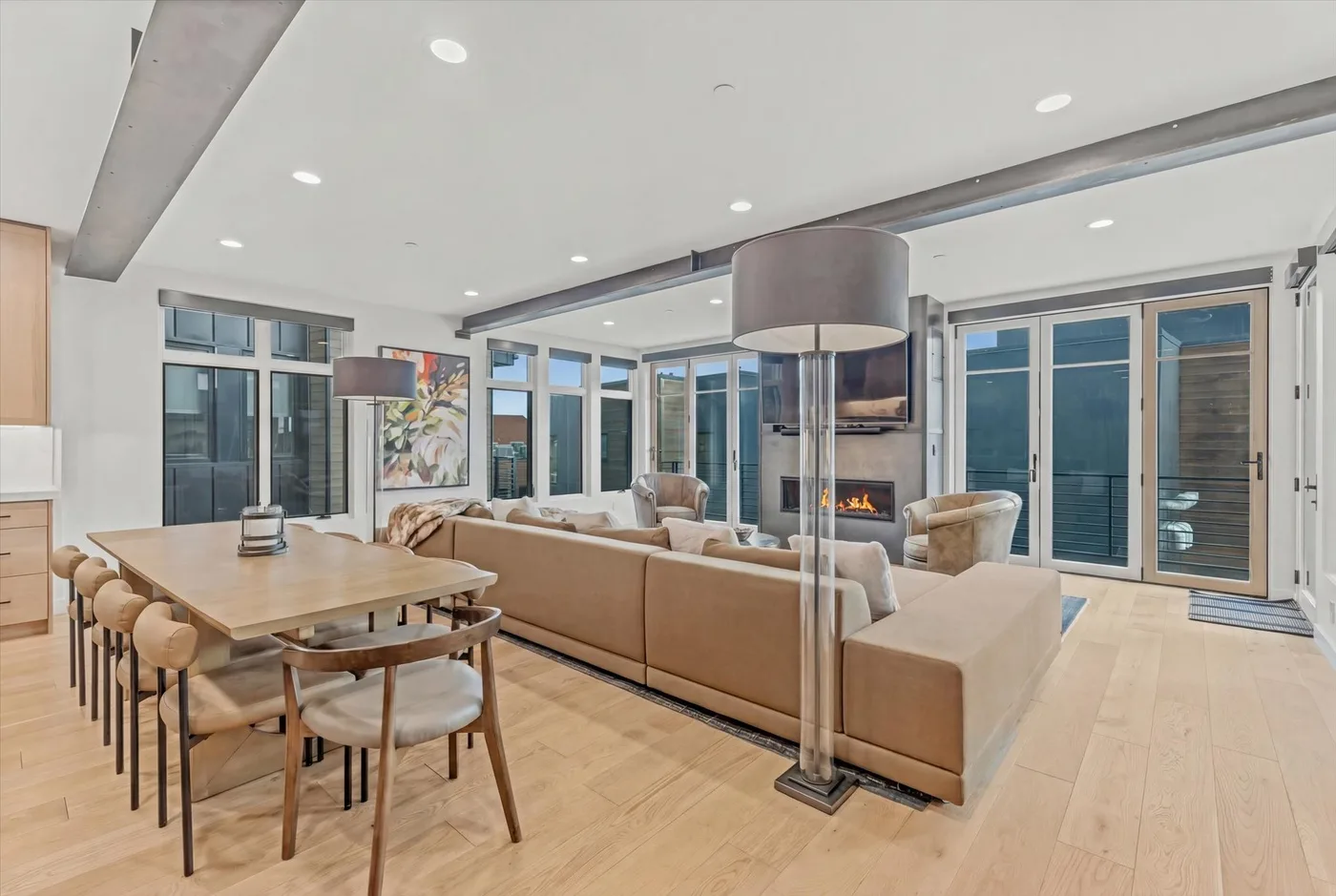 A bright living and dining area features a large seating arrangement and dining table.