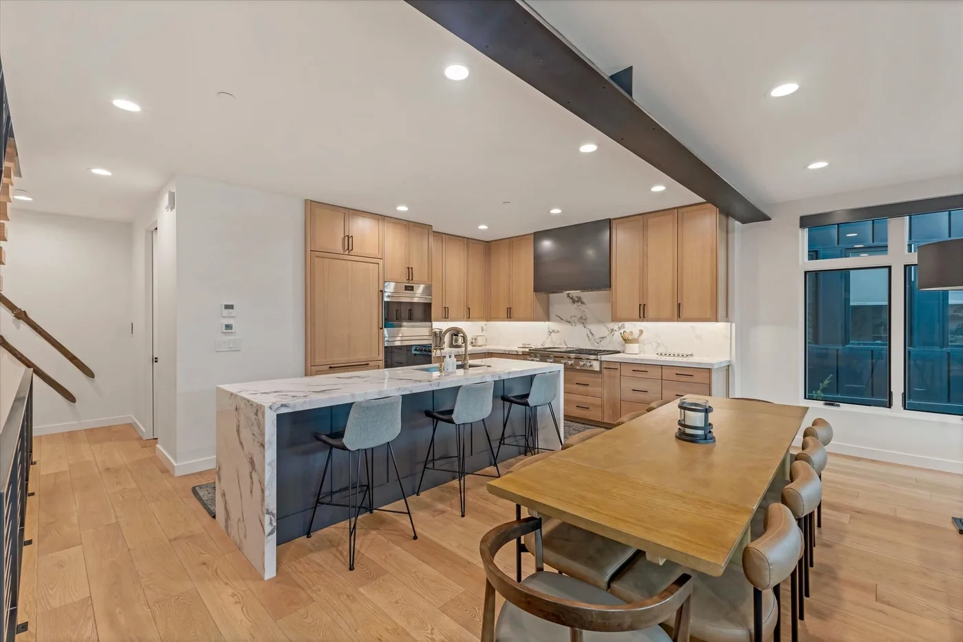 An open-plan kitchen and dining area with a long island and wooden table.