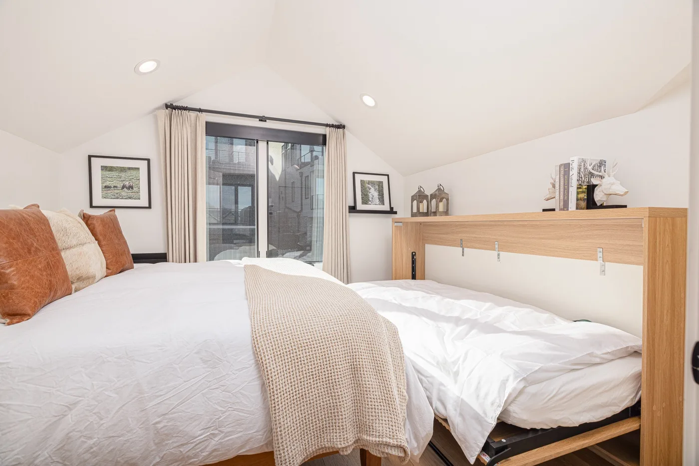 A bright bedroom with a bed, light bedding, and a window with curtains.