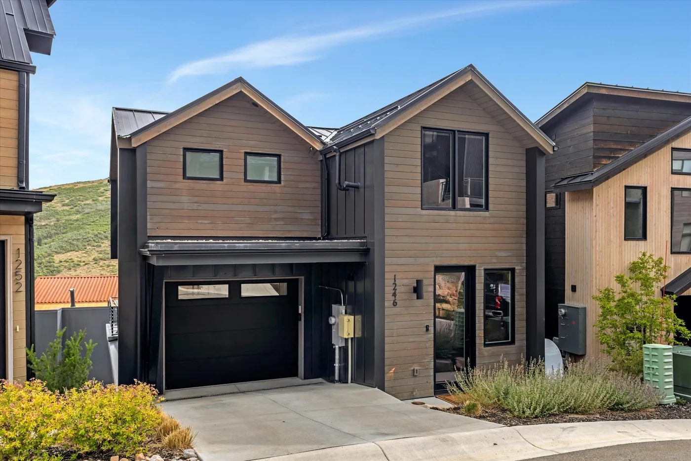 A modern two-story house with a garage and a paved driveway.
