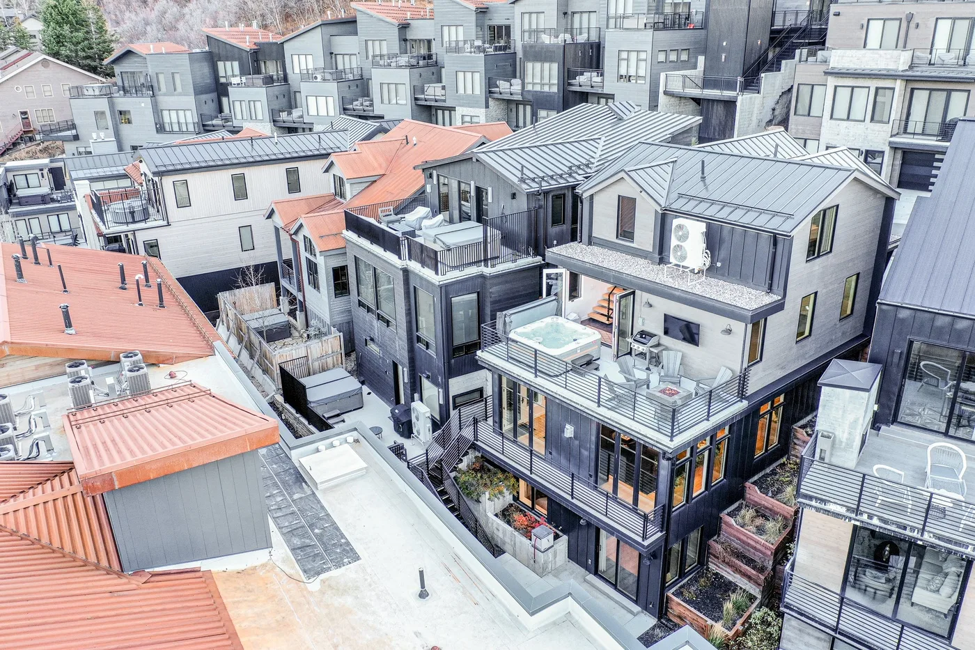 Aerial view of closely grouped modern buildings with balconies and metal roofs.