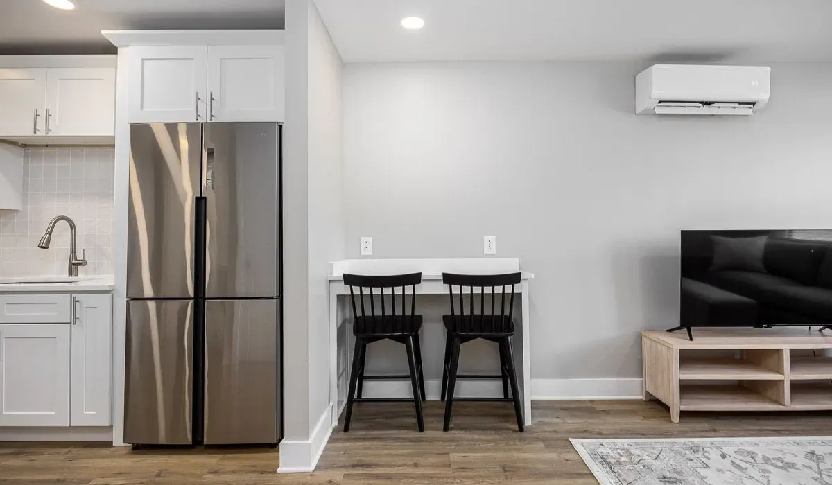 Cocina y sala de estar de concepto abierto con una barra de comedor y un televisor.