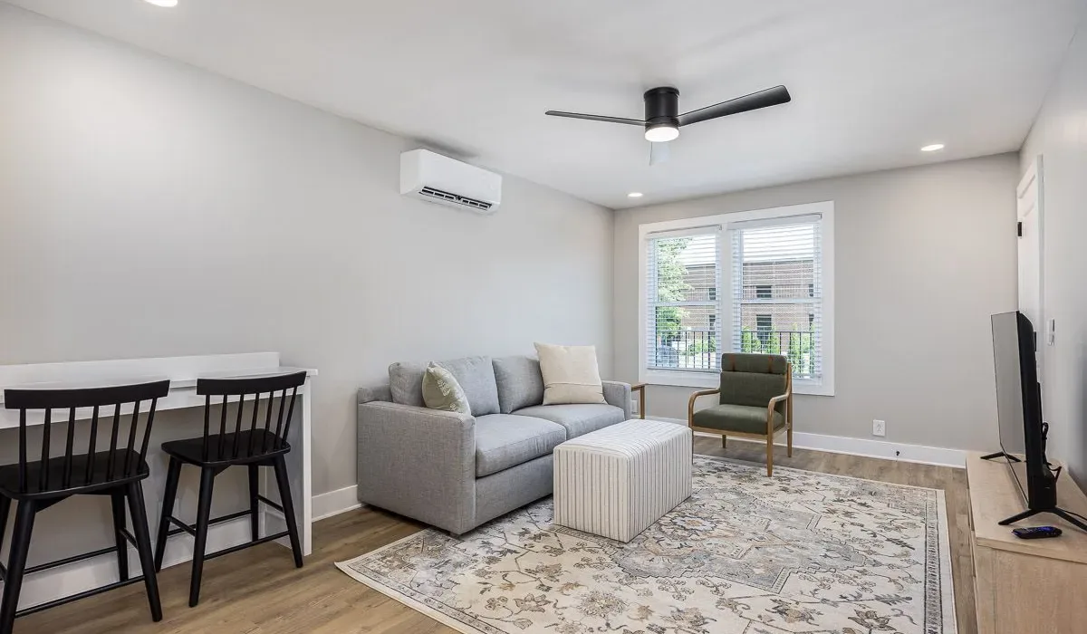 Una sala de estar luminosa con sofá, sillón y mesa de centro.
