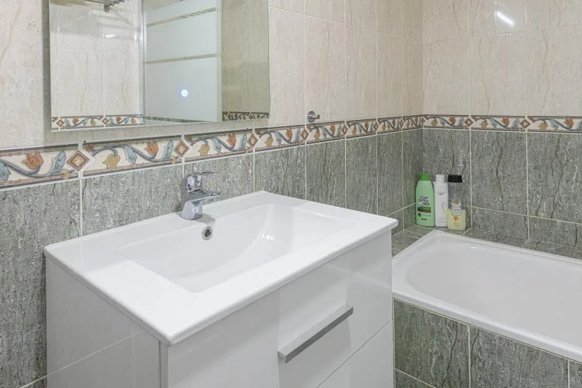 Un baño alicatado con lavabo y bañera.