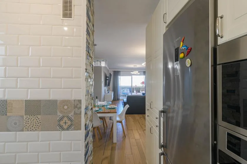 La cocina se abre a un comedor y una sala de estar con piso de madera.