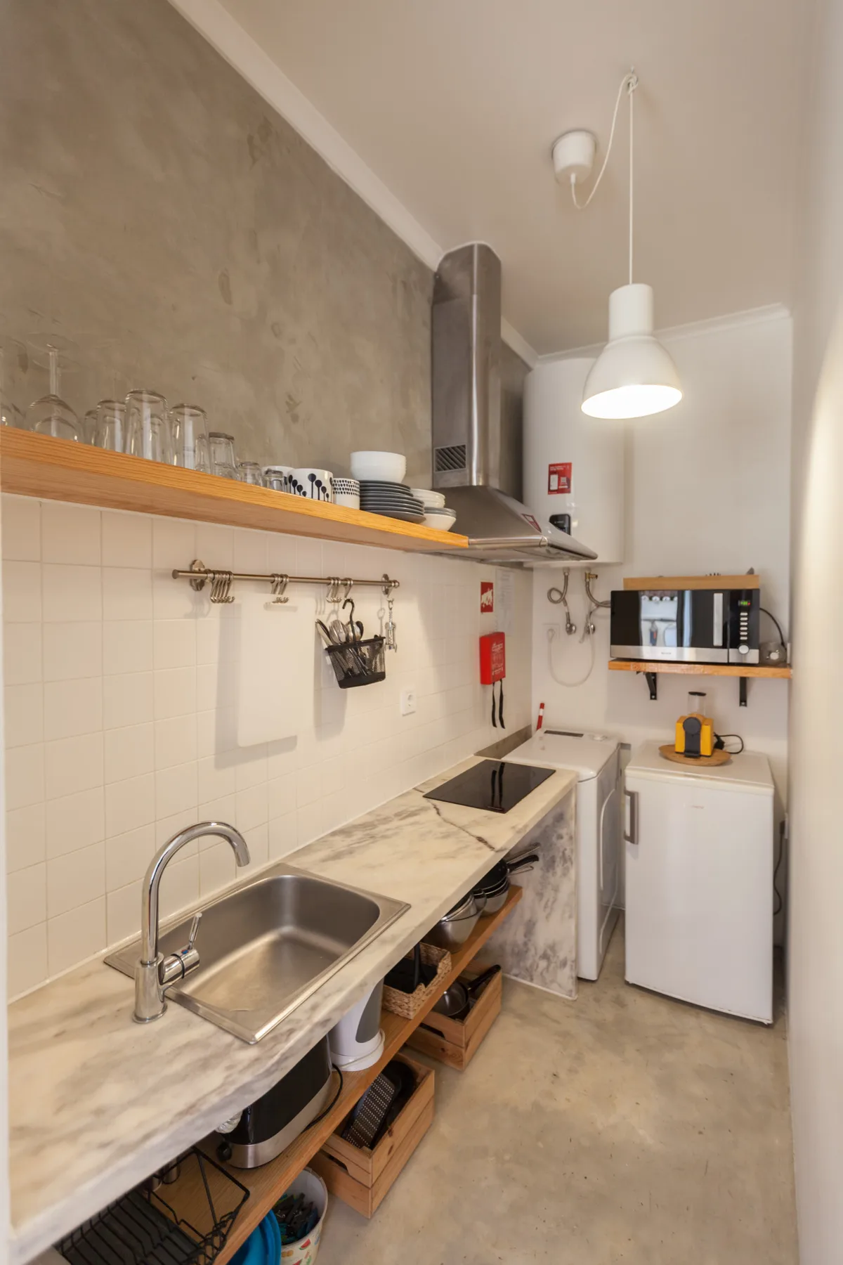 Una cocina compacta con una encimera larga, un fregadero y un microondas.