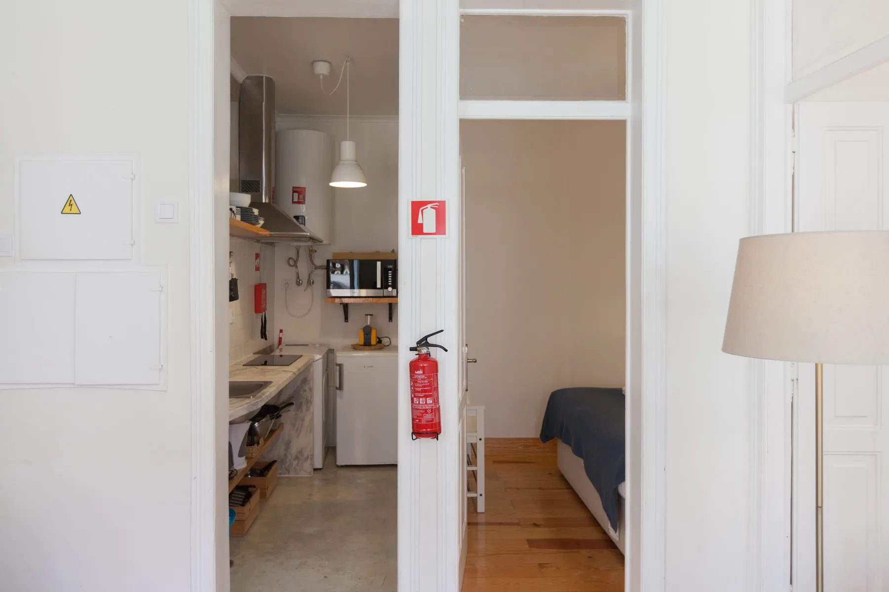 Interior de un apartamento compacto con una pequeña cocina y una zona para dormir.