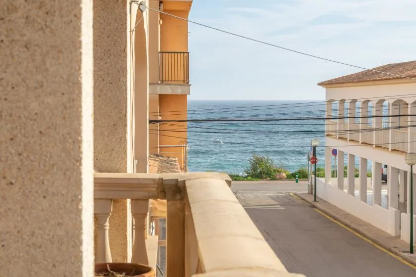 Una calle junto al mar pasa entre edificios hacia el agua.