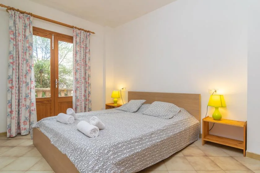 Un dormitorio con una cama grande, cortinas estampadas y lámparas de noche.