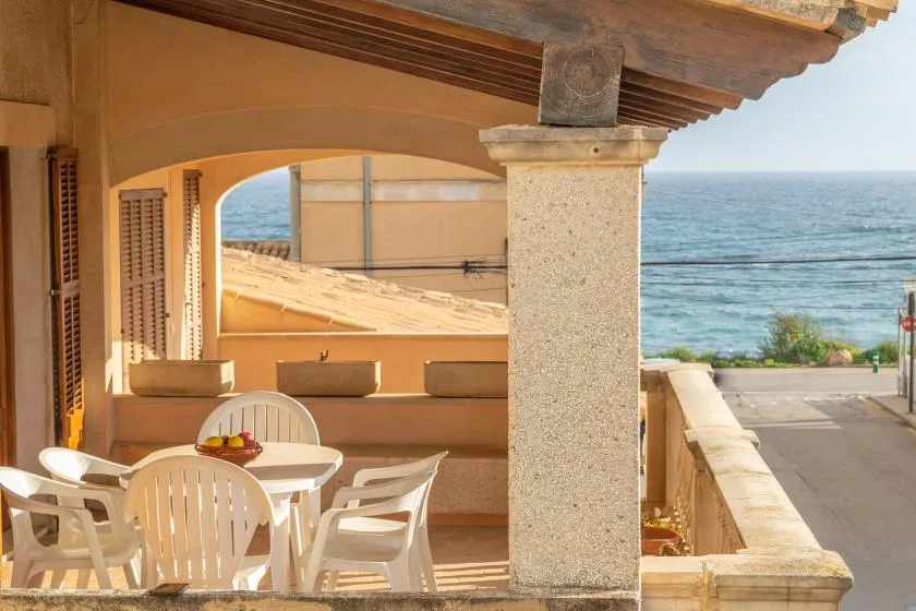 Un patio cubierto con asientos al aire libre tiene vistas al mar.