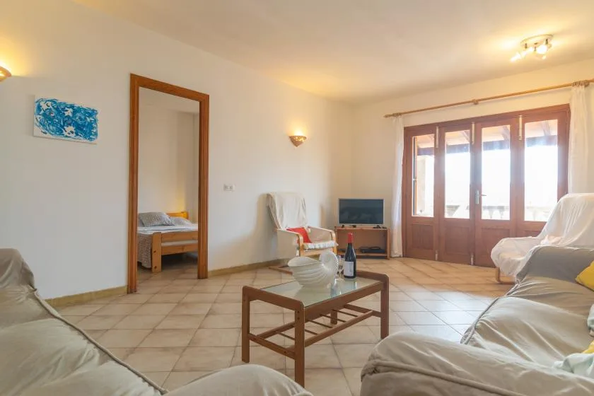 Una sala de estar con asientos, una mesa de centro y grandes ventanas.