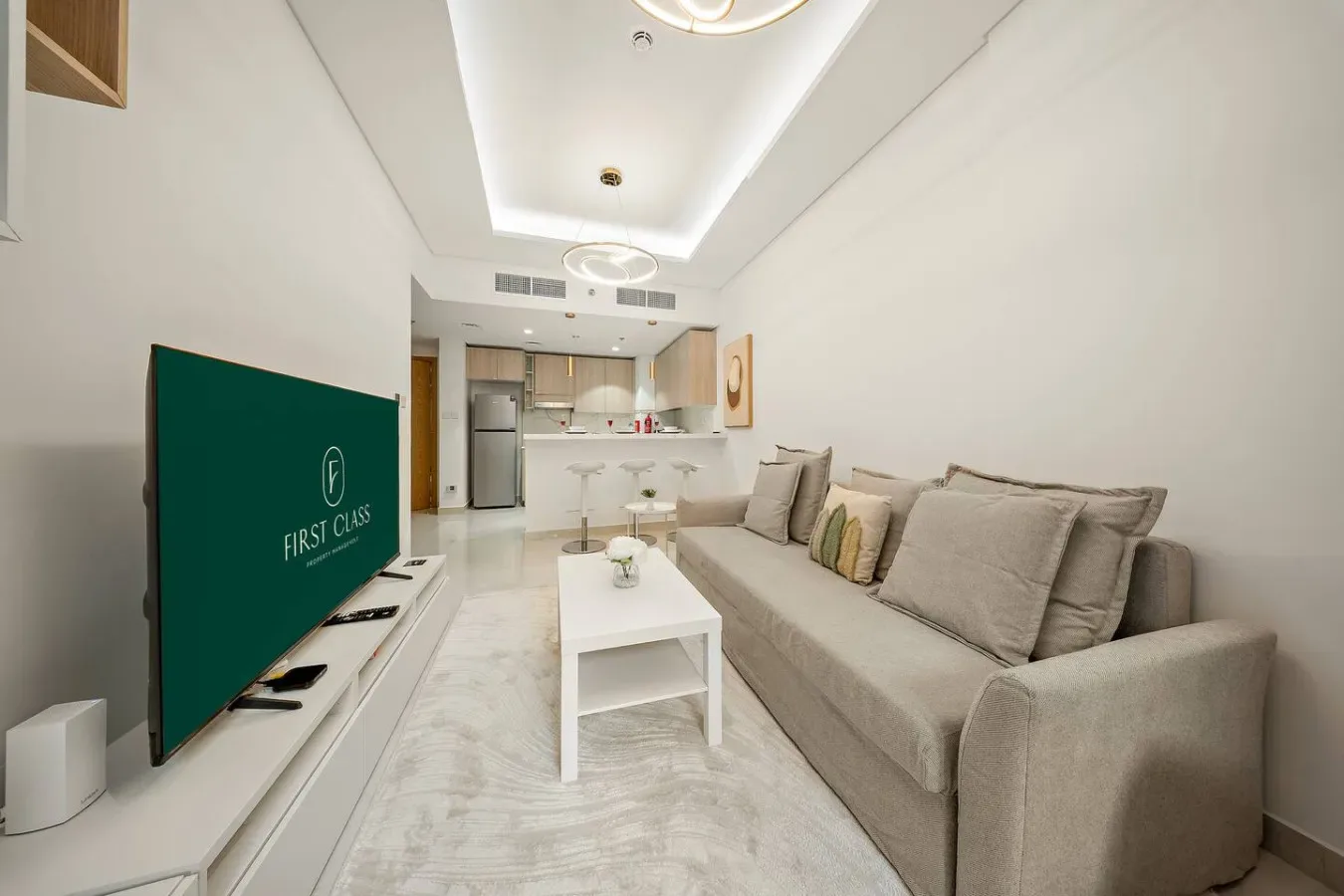 A bright living room with seating, a coffee table, and an open kitchen.