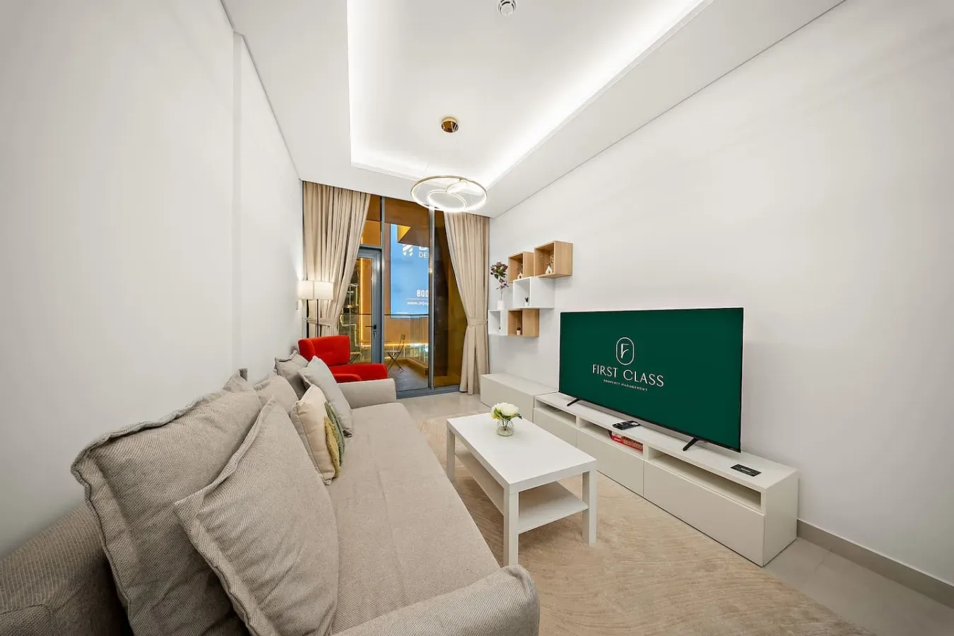 A bright living room with seating, a coffee table, and a television.