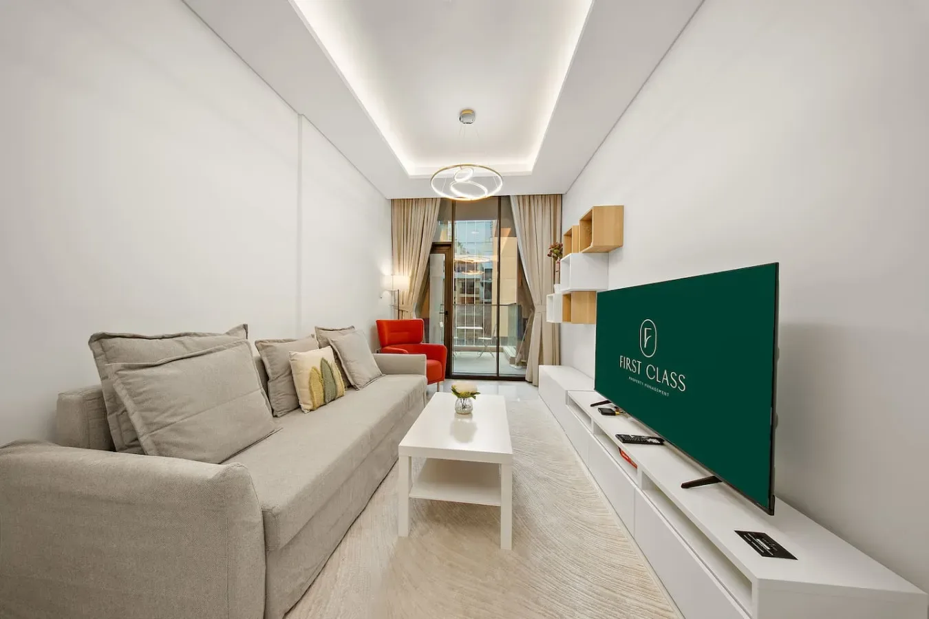 A bright living room with a sofa, coffee table, and television.