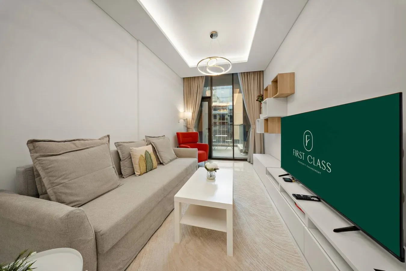 A bright living room with a sofa, coffee table, and large television.