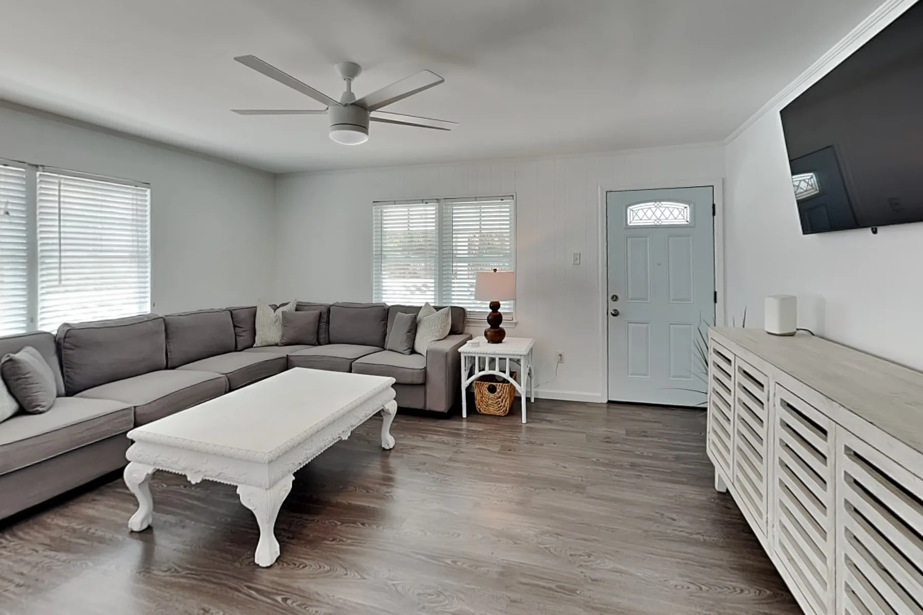 A living room with sectional seating, a coffee table, and a television.