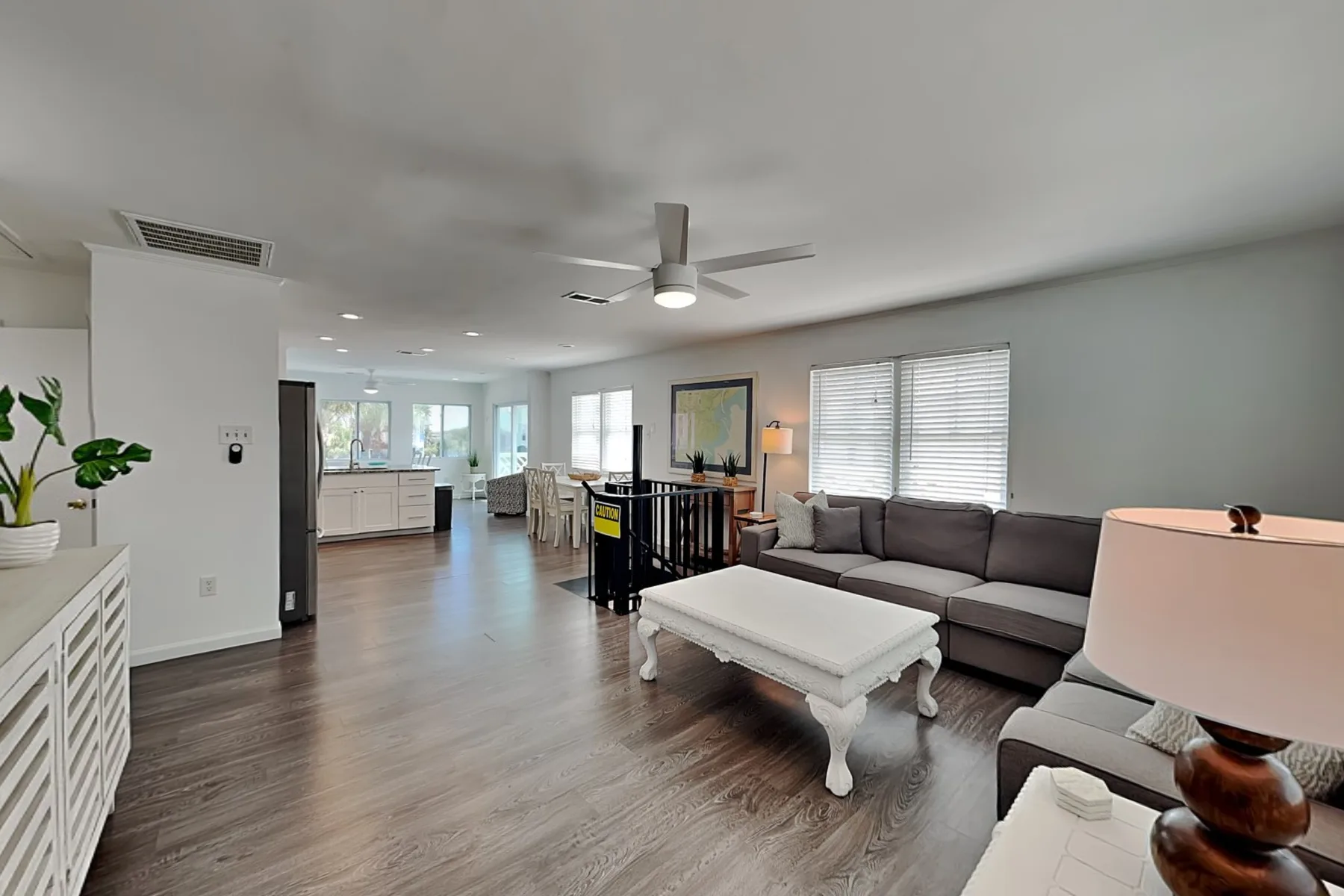 A bright living room with seating, a coffee table, and an open kitchen.