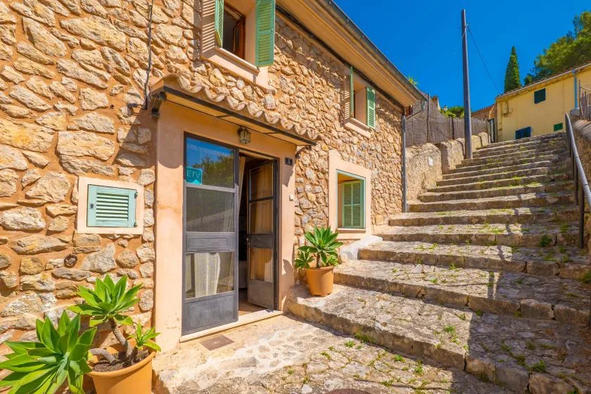 A stone building entrance opens onto broad outdoor steps.