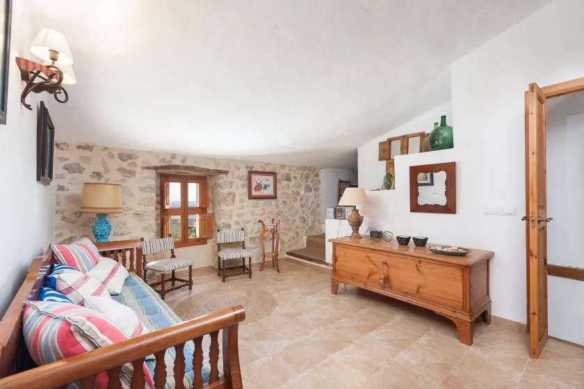 A living room with seating, a wooden chest, and a stone accent wall.