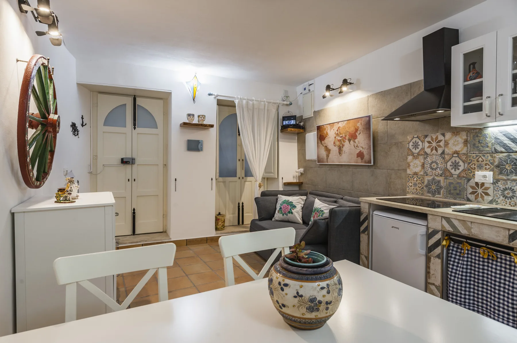 Una cocina con zona de comedor, encimera, armarios y mesa.