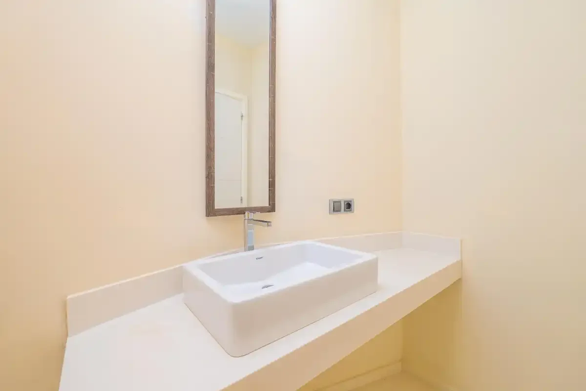 A bathroom vanity with a rectangular vessel sink and wall mirror.