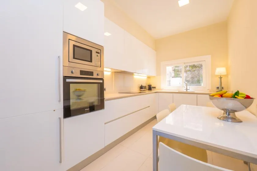 A bright modern kitchen with white cabinetry and a central island.