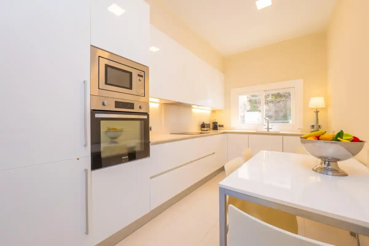 A bright modern kitchen with white cabinetry and a central island.
