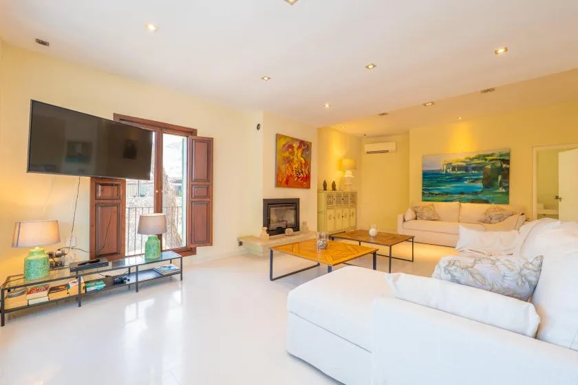 A bright living room with seating, a television, and a coffee table.