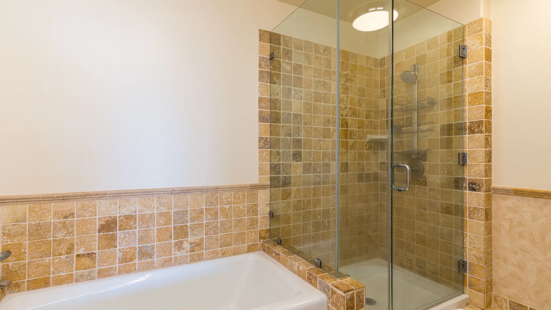 Un baño con azulejos, bañera y ducha de vidrio.
