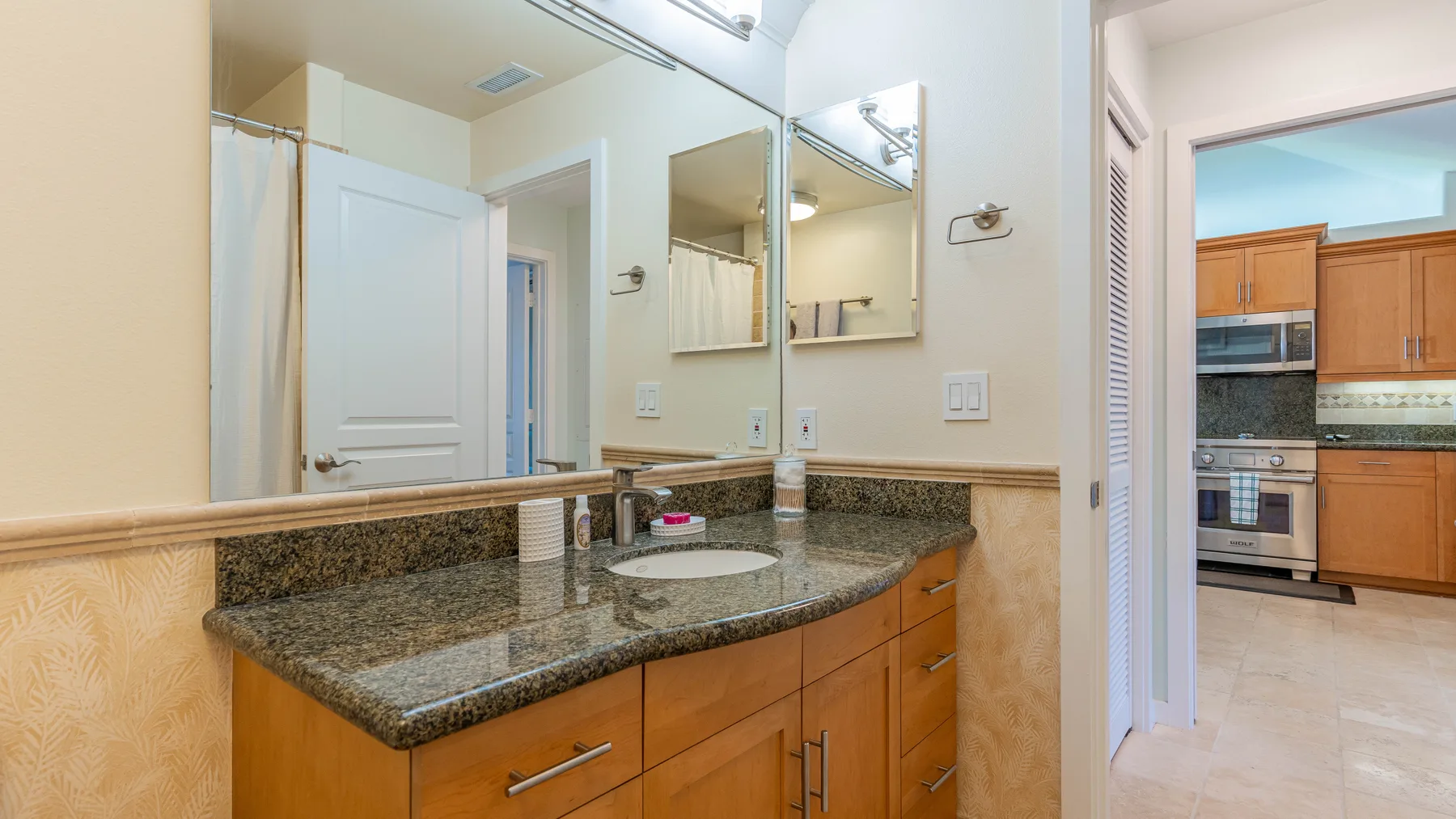 Un tocador de baño con un espejo amplio y un lavabo.
