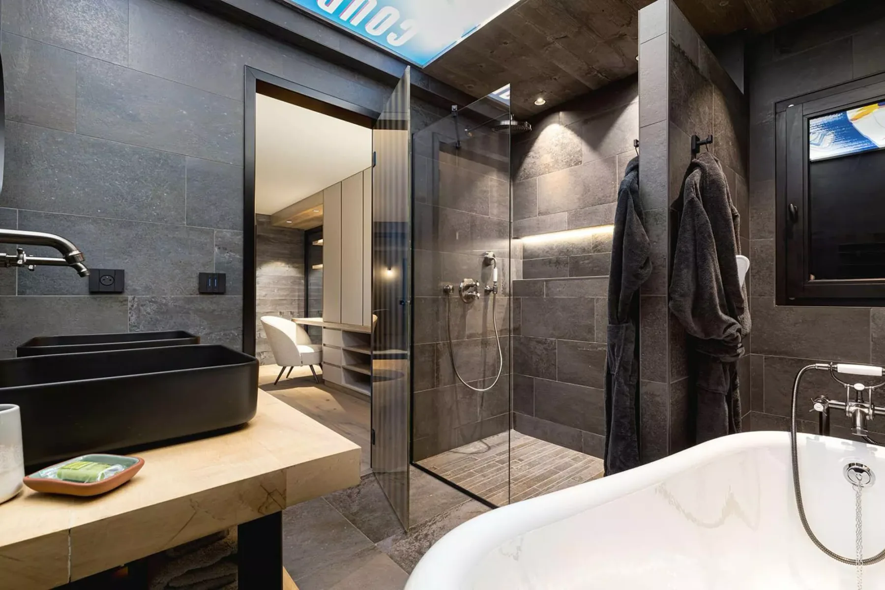 A modern bathroom with a sink, glass shower, and bathtub.