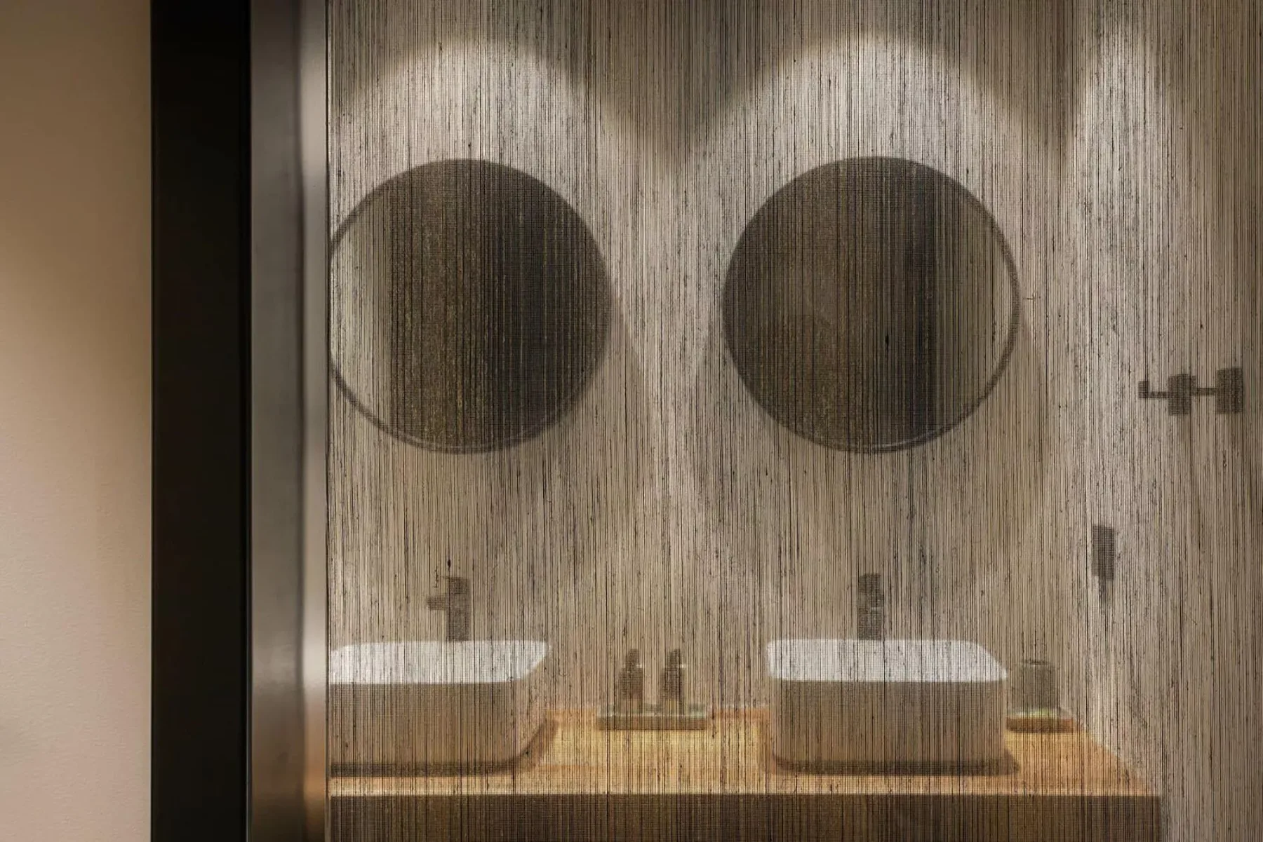 A bathroom vanity with two round mirrors above the sinks.