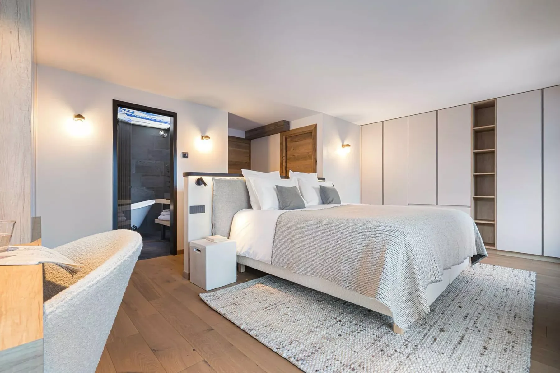 A bright bedroom with a neatly made bed and built-in wardrobes.