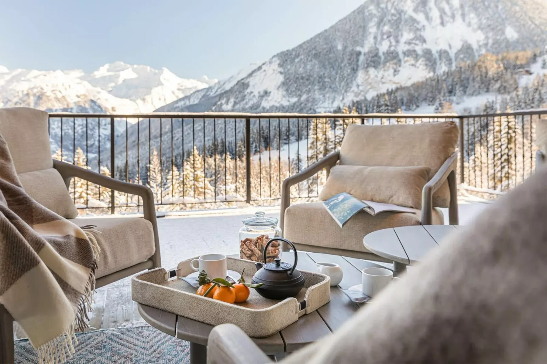 A balcony seating area overlooks a snowy mountain landscape.