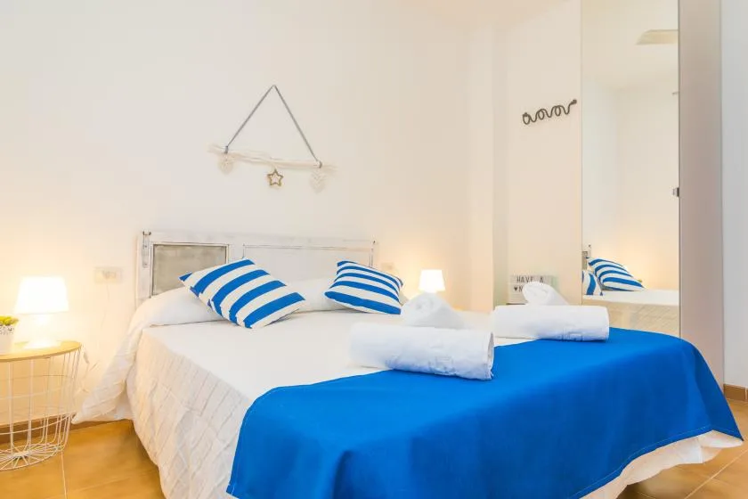 Un dormitorio con una cama vestida con ropa de cama azul y blanca.