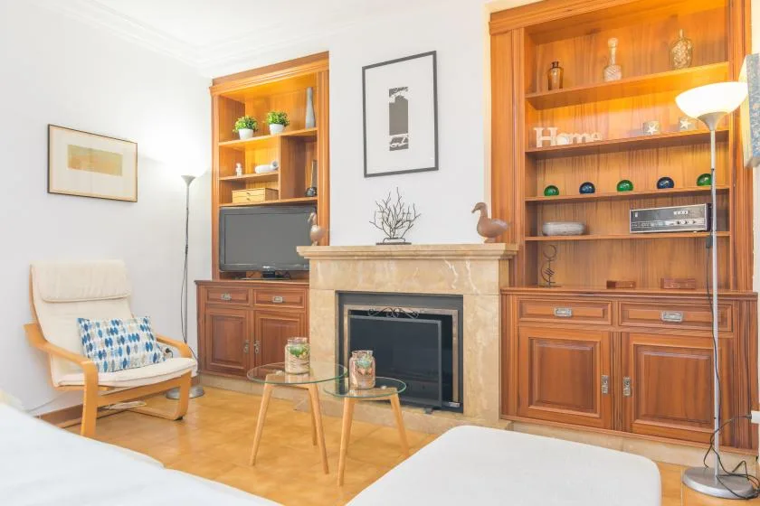 Una sala de estar con chimenea, estanterías de madera y una zona para sentarse.
