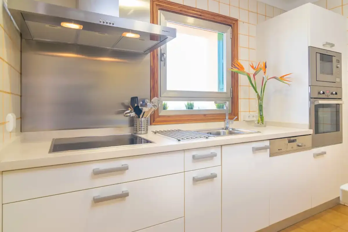 Una cocina moderna y luminosa con placa de cocción, fregadero y electrodomésticos integrados.
