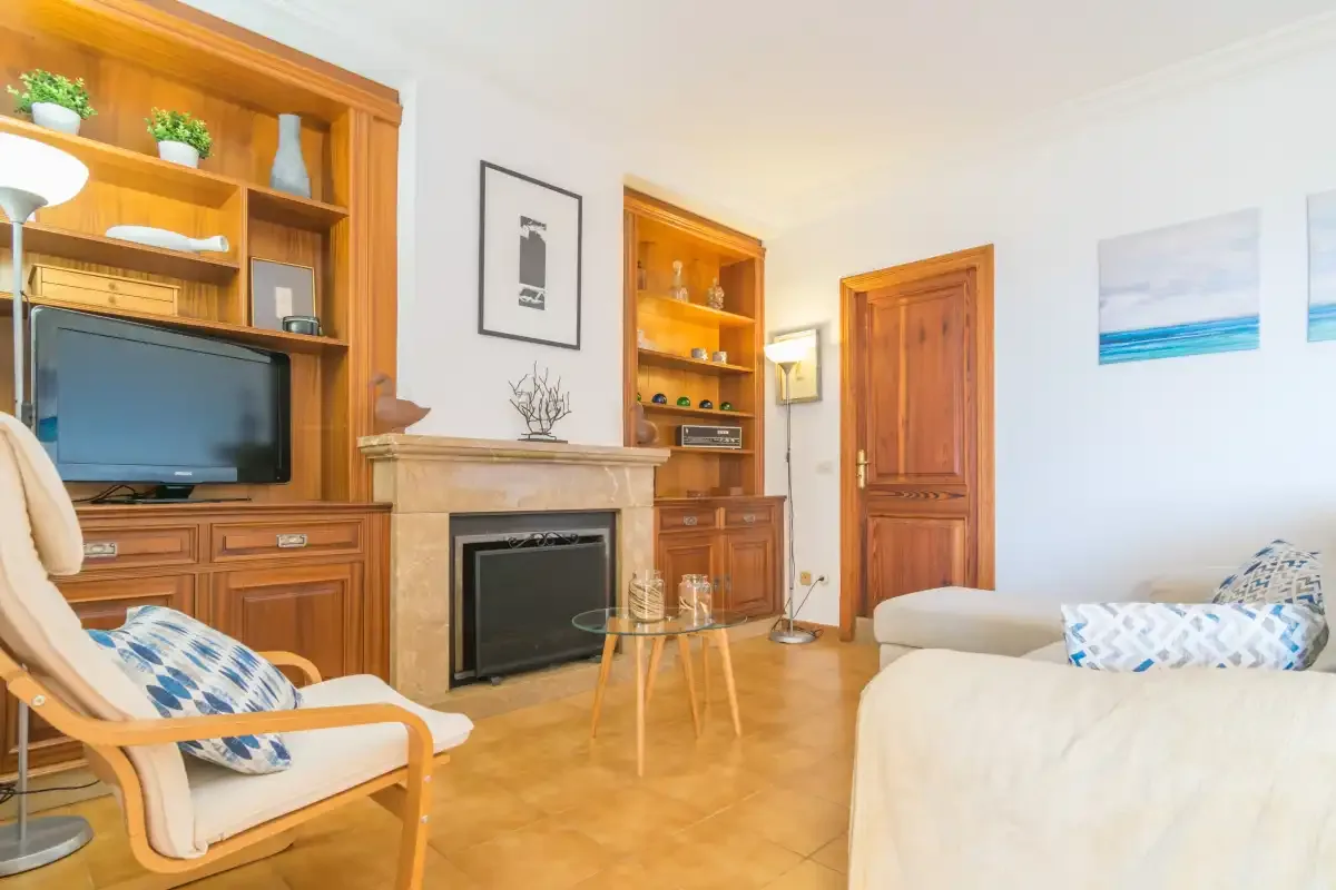 Un salón con armarios de madera, una chimenea y asientos.