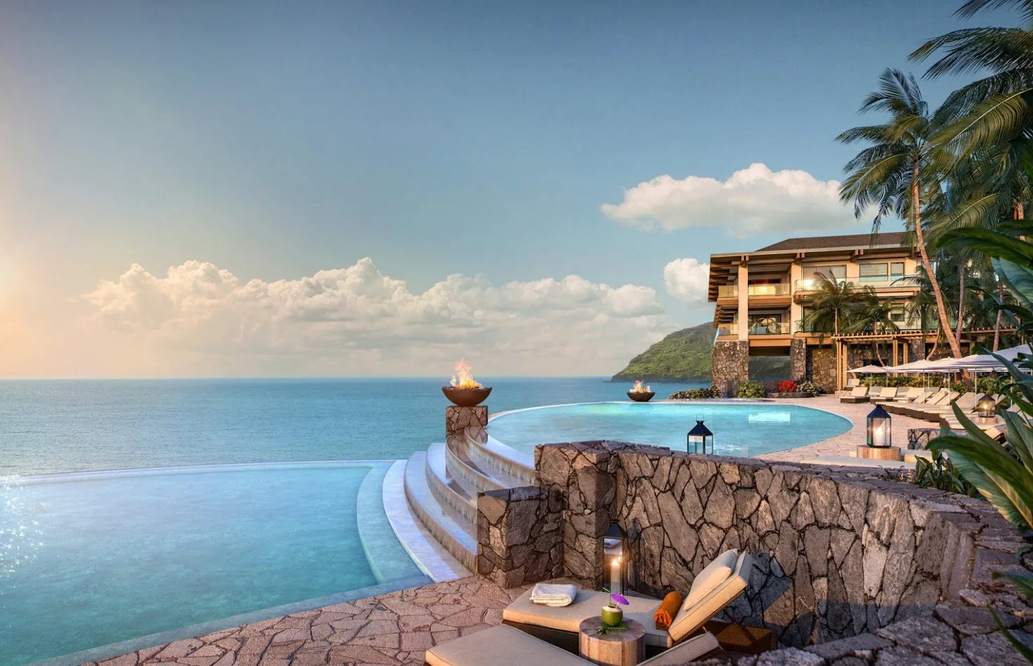 A seaside resort pool overlooks the ocean beside a stone terrace.