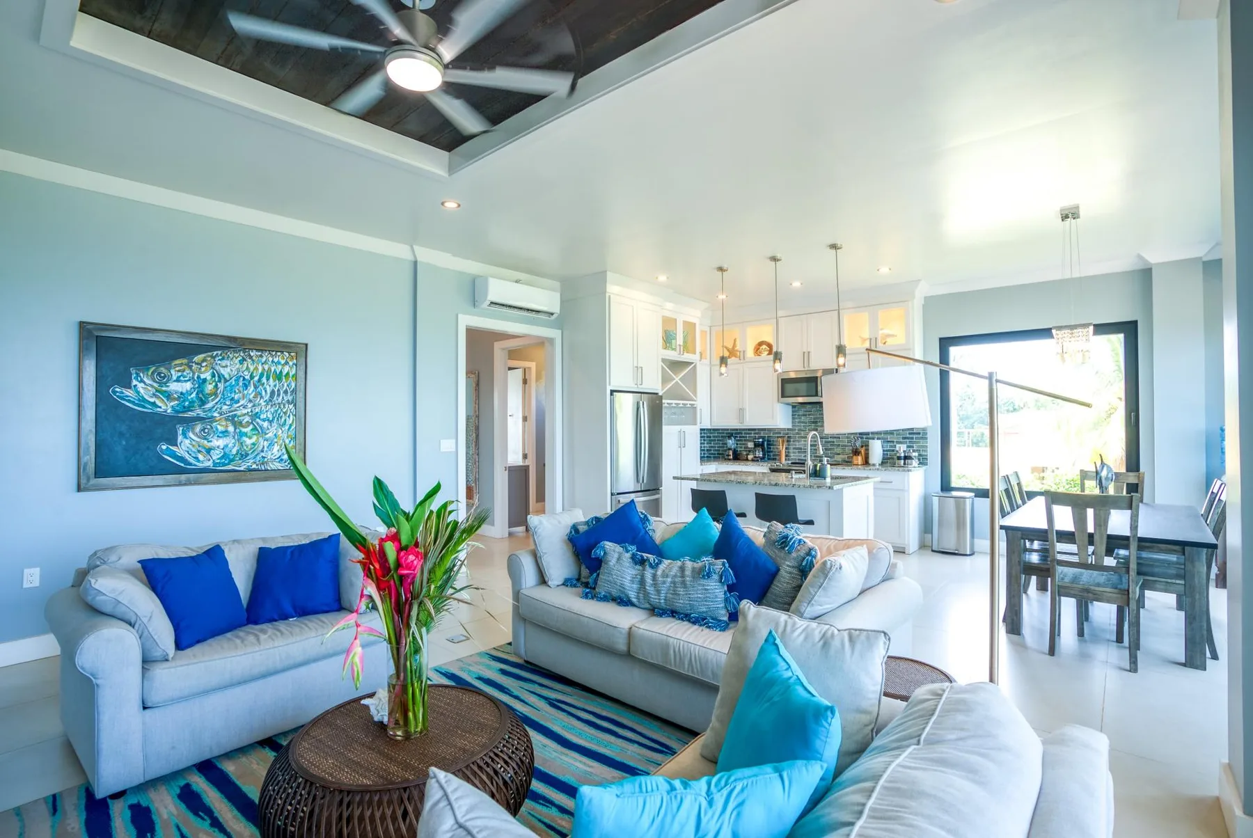 A bright living room opens onto a kitchen and dining area.