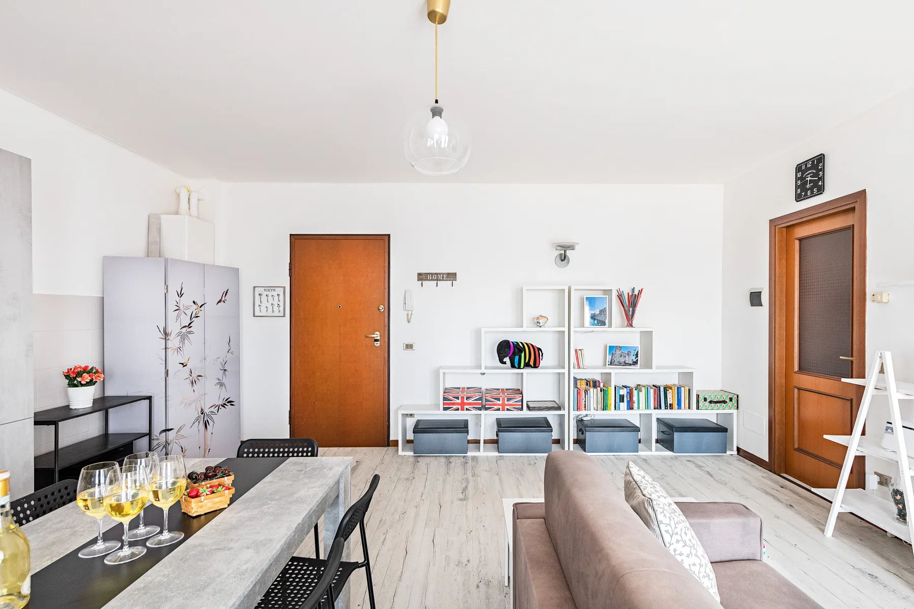 Una sala luminosa con una mesa de comedor y estanterías junto a la pared.