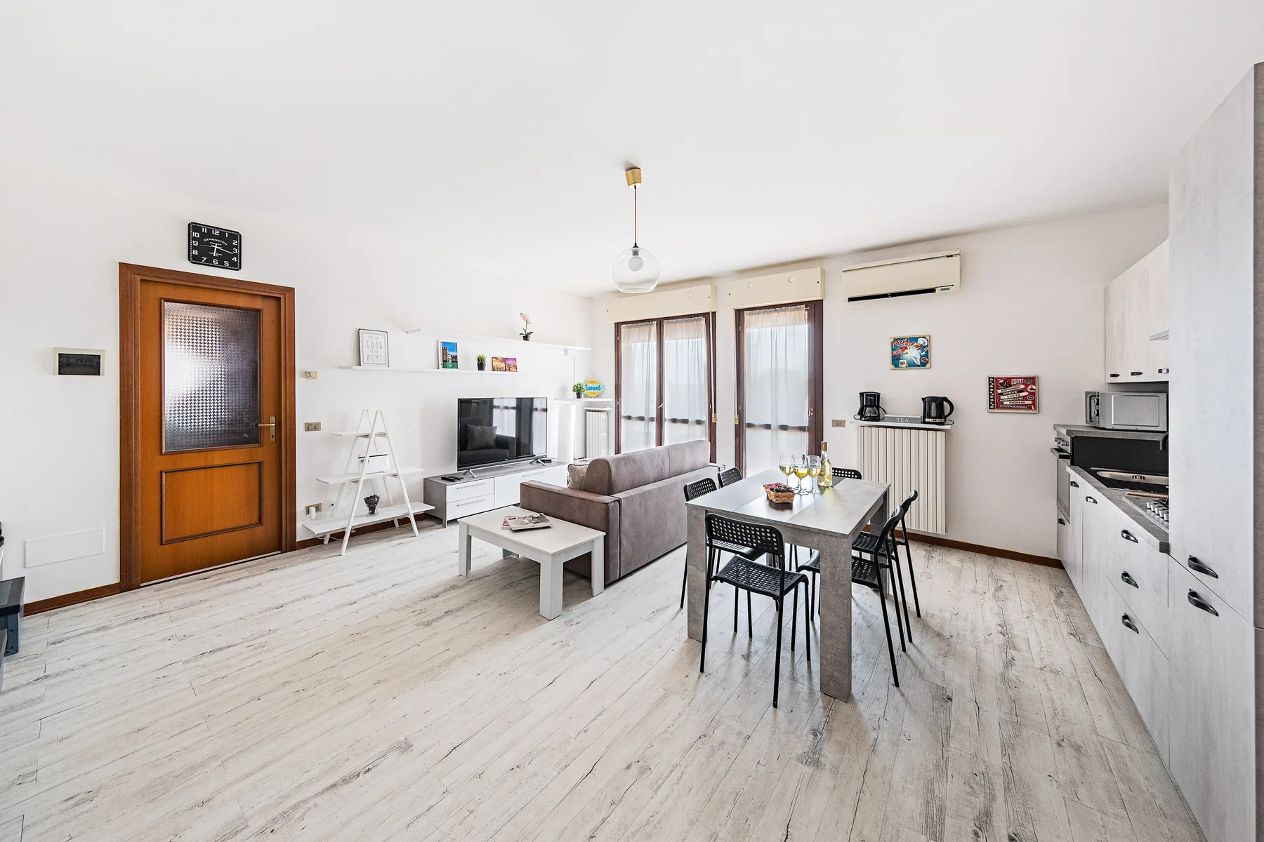 Una luminosa sala de estar y comedor de concepto abierto, con televisor y cocina.