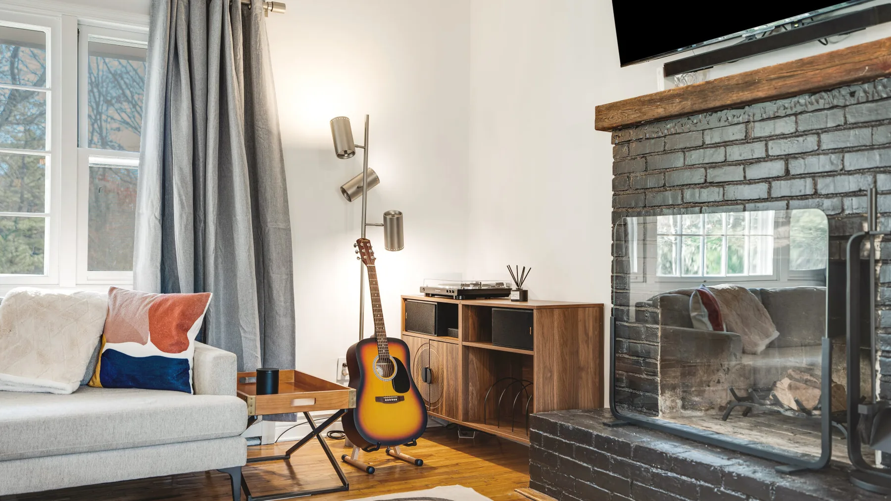 Una sala de estar con asientos, una guitarra y una chimenea.