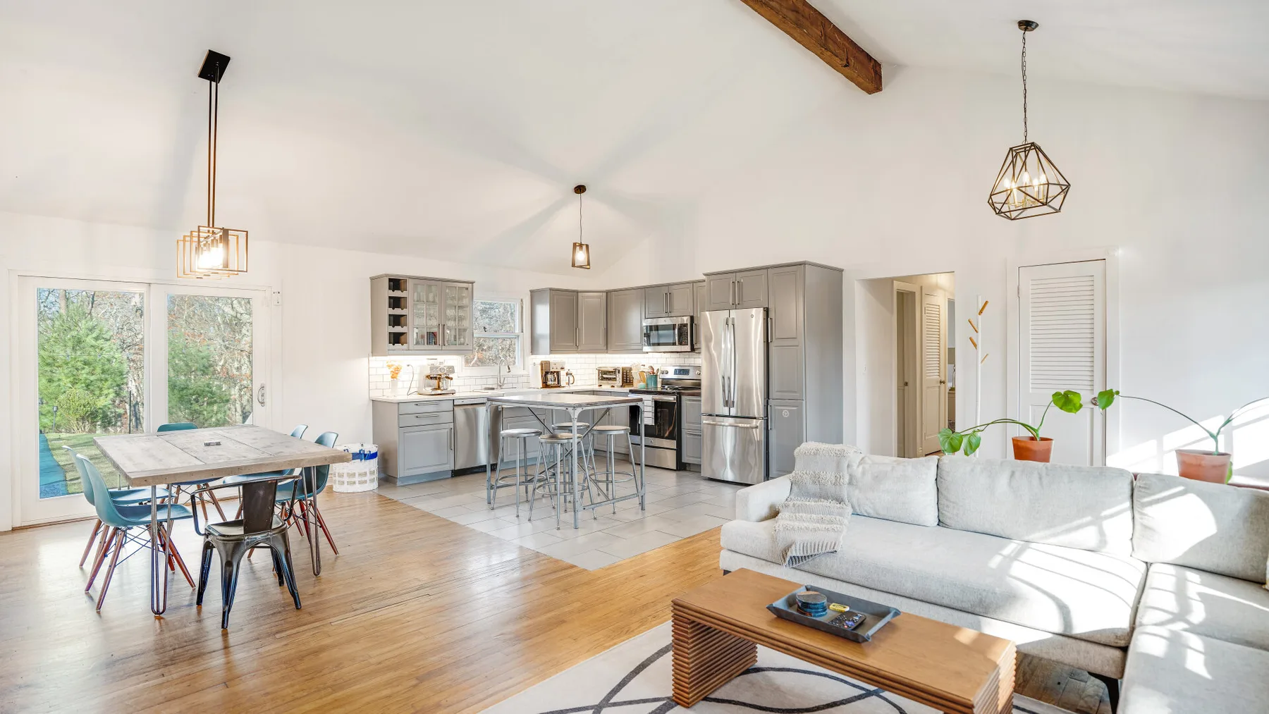 Una sala de estar y cocina de planta abierta con mesa de comedor y asientos.
