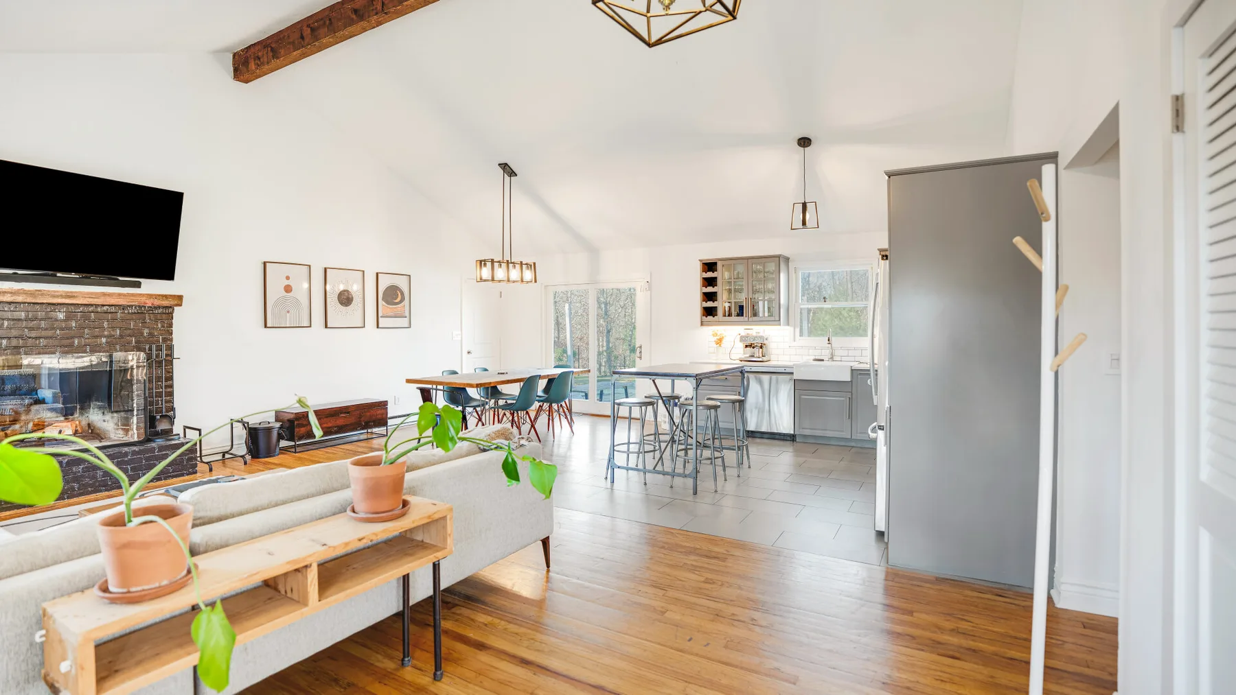 An open-plan living and dining area with a kitchen and wooden floors.