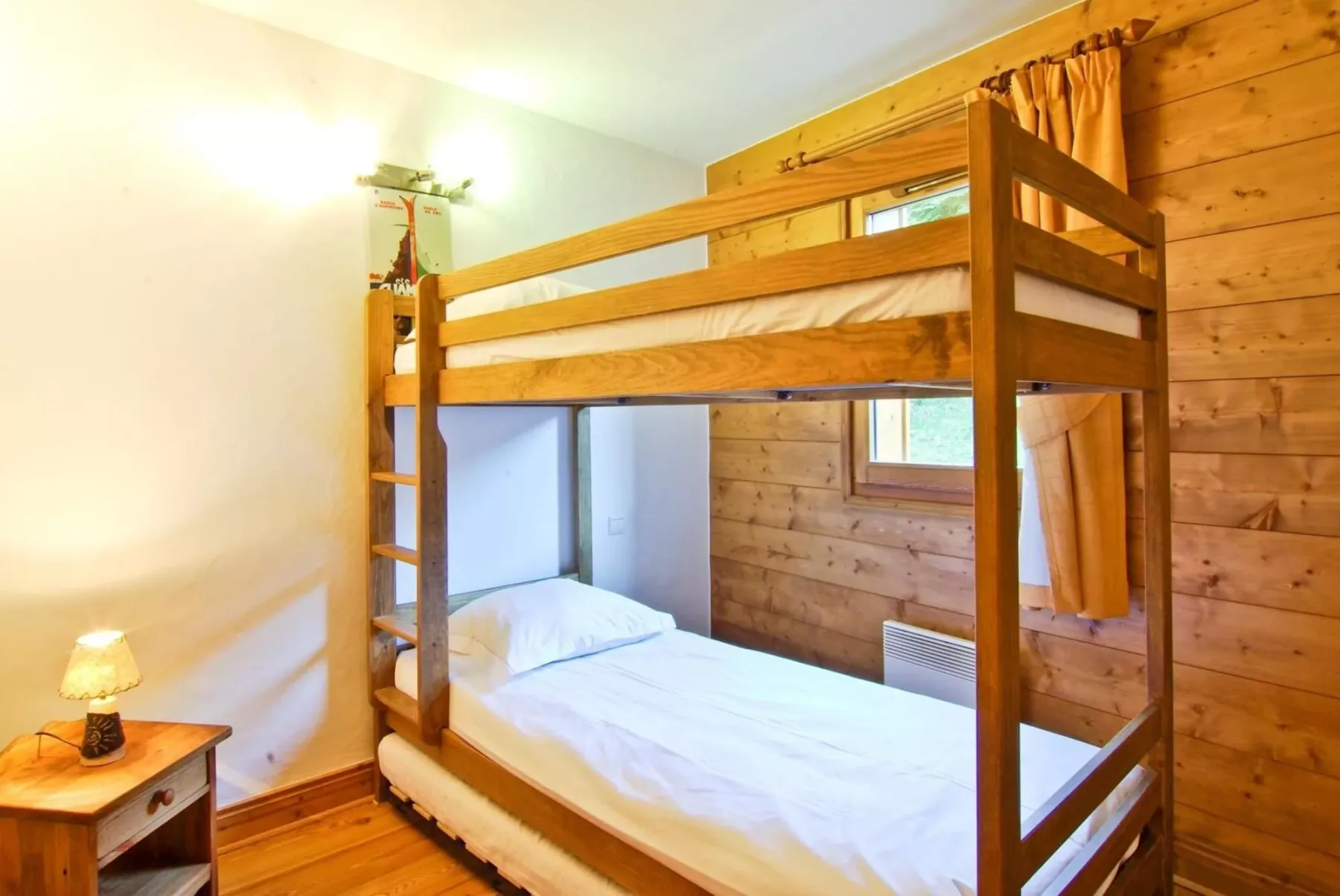 A wooden bunk bed fills a bedroom with wood-paneled walls.