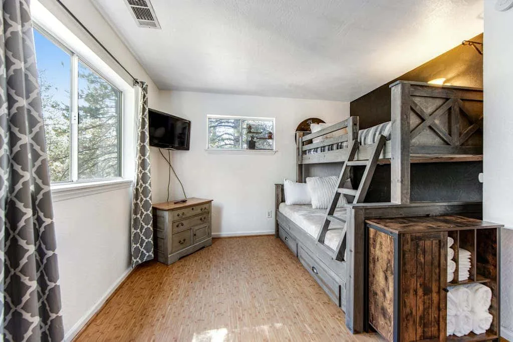 Un dormitorio con literas, una ventana y suelo de madera.