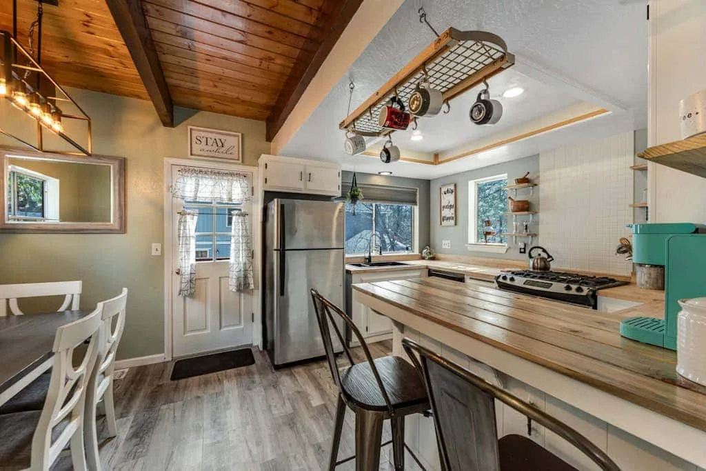 Una cocina y comedor con una barra larga y techo de madera.